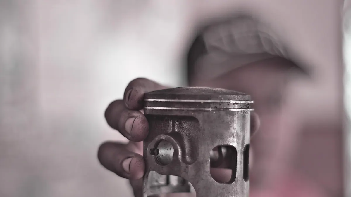 Piston de moteur tenu par un mécanicien